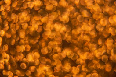 Oval sarı nesnelerden yapılmış doku. Etki, simli yüzeyi odaklanmadan makro ölçekte fotoğraflayarak elde edildi..