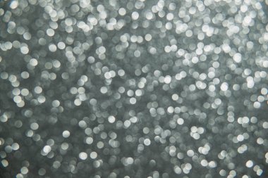 Doku oval gri nesnelerden yaratıldı. Etki, simli yüzeyi odaklanmadan makro ölçekte fotoğraflayarak elde edildi..