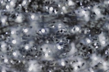 Aydınlık Noel süslemesi bulanık bir etki yaratmak için odak noktasını kasıtlı olarak kaydırarak fotoğraflandı.