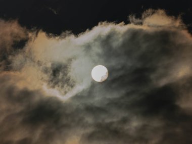 Gökyüzü tamamen bulutlu, ince bir bulut tabakasıyla kaplı. Bulutların arasından güneşin diskini görebilirsin..