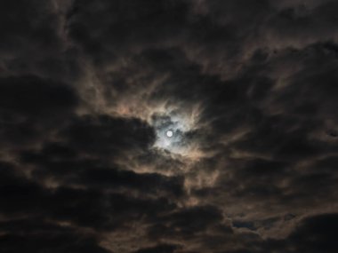 Gökyüzü tamamen bulutlu, ince bir bulut tabakasıyla kaplı. Bulutların arasından güneşin diskini görebilirsin..