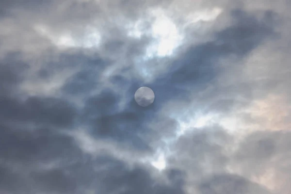 空は完全に雲の薄い層で覆われて曇っている 雲の中から太陽の円盤が見えます — ストック写真