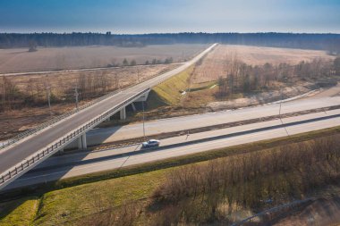 Uçsuz bucaksız. İki yolun kesişmesiz kavşağı. Biri iki şeritli, diğeri üstgeçitten geçiyor. İnsansız hava aracından görüntüle.