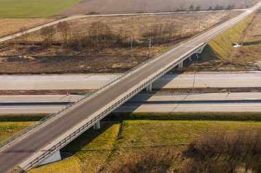 Uçsuz bucaksız. İki yolun kesişmesiz kavşağı. Biri iki şeritli, diğeri üstgeçitten geçiyor. İnsansız hava aracından görüntüle.