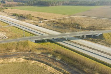 Uçsuz bucaksız. İki yolun kesişmesiz kavşağı. Biri iki şeritli, diğeri üstgeçitten geçiyor. İnsansız hava aracından görüntüle.
