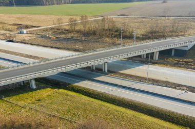 Uçsuz bucaksız. İki yolun kesişmesiz kavşağı. Biri iki şeritli, diğeri üstgeçitten geçiyor. İnsansız hava aracından görüntüle.