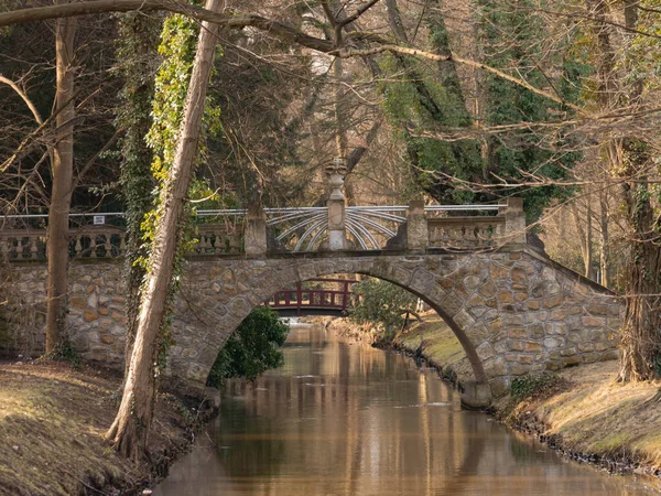 一条流过公园的小河 河上有一座砖砌的 历史性的石桥 今天是阳光灿烂的一天 — 图库照片