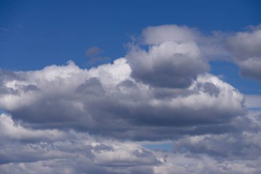 Güneşli bir bahar günü. Mavi gökyüzü dalgalanan beyaz-gri bulutlarla kaplı. Bulutlar gökyüzünü kısmen karartıyor.