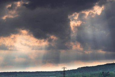 Sudeten Upland 'da. Tarıma elverişli tarlalar, çayırlar ve ormanlarla kaplı dalgalı bir arazi. Uzaktan tepeleri görebilirsin. Gökyüzü kısmen kara ve yağmurlu bulutlarla kaplı. İHA 'dan fotoğraf..