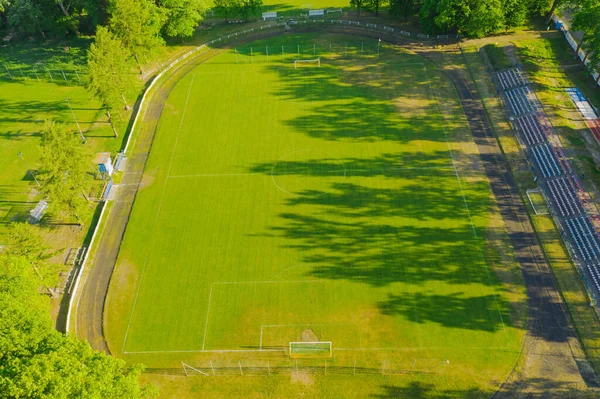 州立競技場だ 中央には芝生に覆われたサッカー場があり ランニングコースやファンのための小さなスタンドがあります ドローンからの眺め — ストック写真
