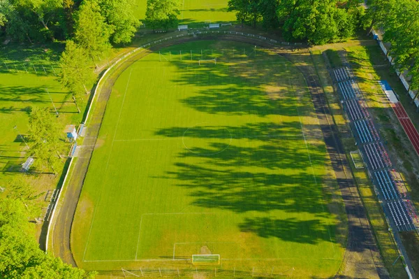 一个省立体育场市中心有一个草地覆盖的足球场 周围有一个跑道和一个小的球迷看台 从无人机看到的 — 图库照片