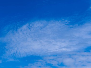 Partly cloudy skies. It is covered with white, delicate, feathery clouds, between which you can see the blue of the sky. It's a sunny day.