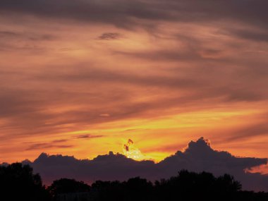 Evening, slightly cloudy sky. The clouds are colored red with the light of the setting sun. You can see the blue sky in some places.