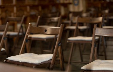 Kilisede ya da karanlık odada boş sandalyeler sıcak ışık, seçici odak düğün fotoğrafçılığı.