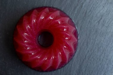 Siyah taş kiremit dokusunda izole edilmiş kırmızı jöle. en üstteki görünüm