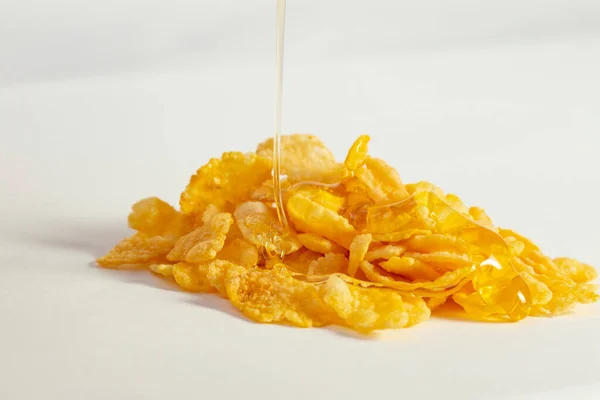 Stapel Cornflakes Met Druppelende Gouden Honing Geïsoleerd Wit Selectieve Focusmacro — Stockfoto