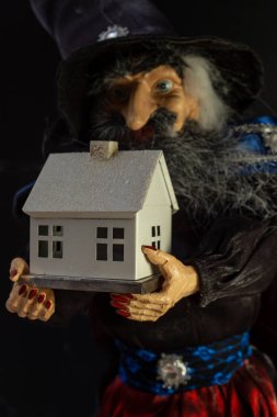 Bulanık büyücü oyuncağı beyaz bir ev tutuyor, maket.