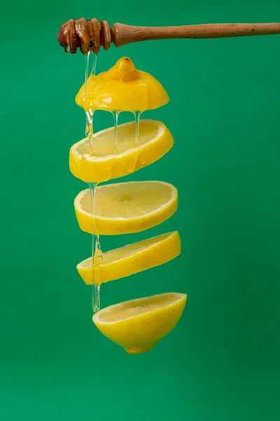 Zitronenscheiben Schweben Auf Grünem Hintergrund Mit Honigtropfen — Stockfoto