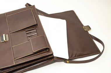 Kahverengi deri bir çantadan çıkan beyaz kağıt.