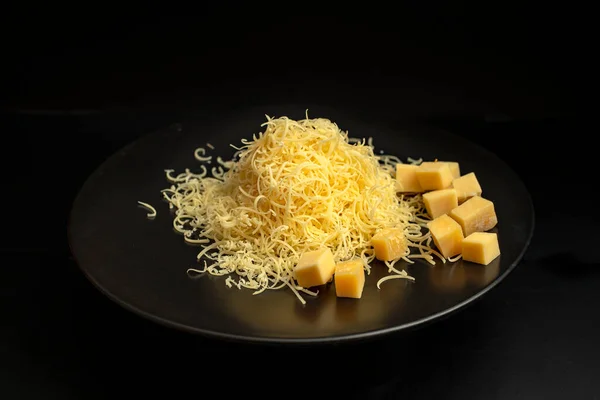 Pile Thin Grated Gouda Cheese Black Ceramic Plate Isolated Black — Stockfoto