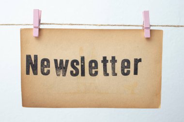 Sarı renkli kağıda yazılmış bülten ve pembe raptiyeli bir halata asılmış. 