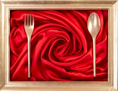 Kırmızı saten girdap ve altın çatal bıçak üzerinde altın çerçeve