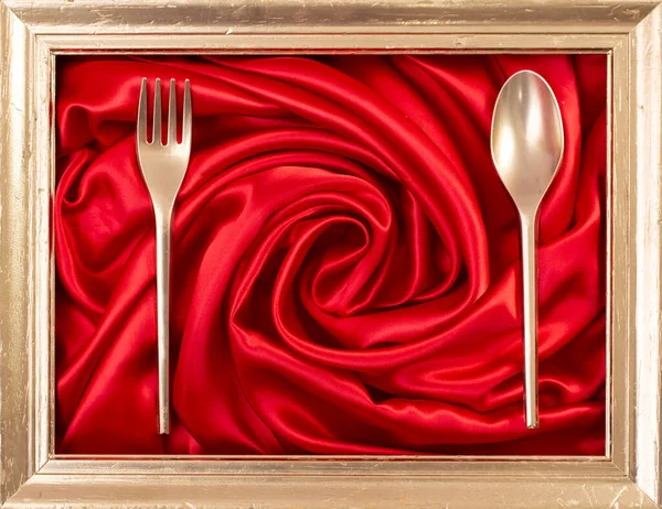 Kırmızı saten girdap ve altın çatal bıçak üzerinde altın çerçeve