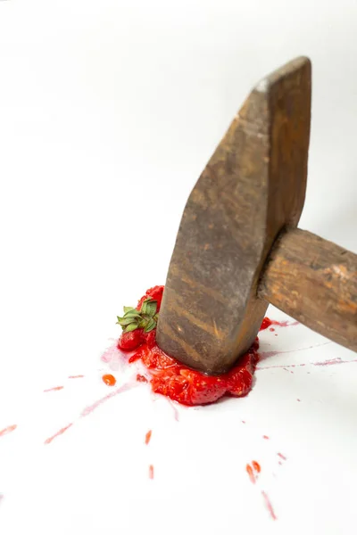 生锈的铁锤砸在白色背景的草莓上 — 图库照片