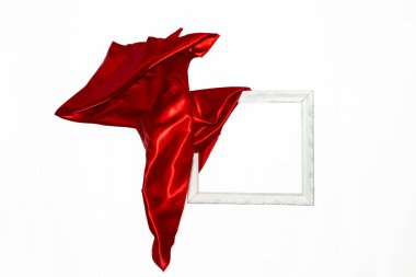 Uçan kırmızı saten beyaz bir çerçeve açıyor, beyaz arka planda izole edilmiş. Yumuşak odak açılış modeli