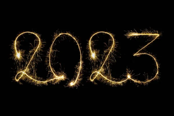 Happy New Year 2023. Number 2023 written sparkling sparklers isolated on black background with copy space for text. Glowing, creative overlay template for holiday greeting card or banner design