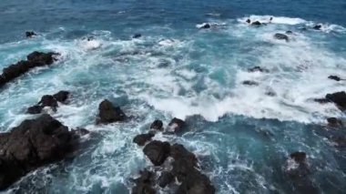 Dalgalar deniz taşı içeren kayalarla çarpışıyor. 4k video.