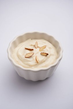 Shrikhand, kuru meyvelerle süslenmiş süzme yoğurttan yapılmış bir Hint tatlısıdır.