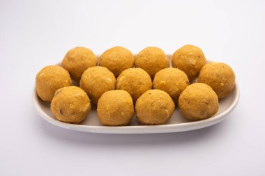 Besan ladoo are delicious sweet balls made with gram flour, sugar, ghee & cardamoms clipart