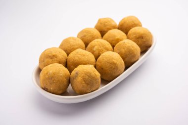 Besan ladoo are delicious sweet balls made with gram flour, sugar, ghee & cardamoms clipart