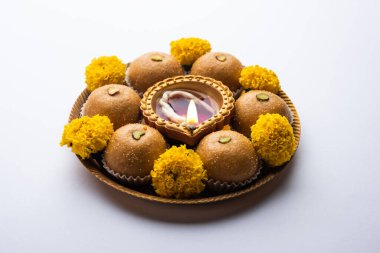 Besan ladoo ve diwali diya veya marigold çiçekleriyle süslenmiş kil lamba - Mutlu bayramlar