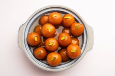 Hint yemeği Gulab Jamun yuvarlak bir seramik kasede servis edilir.