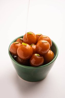 Hint yemeği Gulab Jamun yuvarlak bir seramik kasede servis edilir.