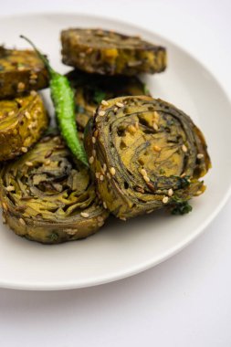 Patra, Paatra, Patrode veya Alu Vadi, Kolocasia yaprakları, pirinç unu, baharat, baharat ve jaggery kullanarak yapılan popüler bir mihrace ve Gujrati aperatifi.