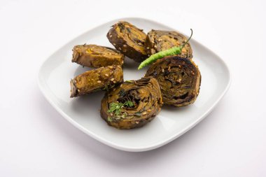 Patra, Paatra, Patrode veya Alu Vadi, Kolocasia yaprakları, pirinç unu, baharat, baharat ve jaggery kullanarak yapılan popüler bir mihrace ve Gujrati aperatifi.