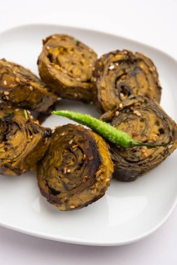 Patra, Paatra, Patrode veya Alu Vadi, Kolocasia yaprakları, pirinç unu, baharat, baharat ve jaggery kullanarak yapılan popüler bir mihrace ve Gujrati aperatifi.