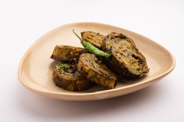 Patra, Paatra, Patrode veya Alu Vadi, Kolocasia yaprakları, pirinç unu, baharat, baharat ve jaggery kullanarak yapılan popüler bir mihrace ve Gujrati aperatifi.
