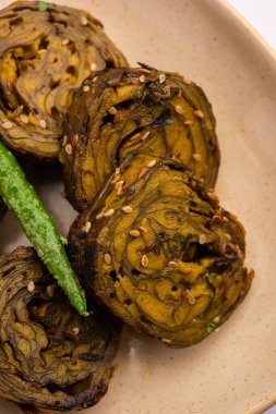 Patra, Paatra, Patrode veya Alu Vadi, Kolocasia yaprakları, pirinç unu, baharat, baharat ve jaggery kullanarak yapılan popüler bir mihrace ve Gujrati aperatifi.