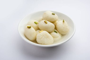 Rasgulla ya da rosogulla. Khoya 'dan yapılmış yumuşak ve süngerimsi bir Hint tatlısı. Sarı peçete ve kahverengi arka planda toprakta.