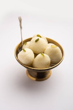 Rasgulla ya da rosogulla. Khoya 'dan yapılmış yumuşak ve süngerimsi bir Hint tatlısı. Sarı peçete ve kahverengi arka planda toprakta.