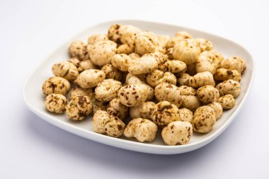 Kavrulmuş Phool Makhana veya Çıtır Masala Nilüfer tohumu bir kasede servis edilir, seçici bir odak noktası.