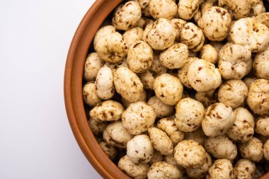 Kavrulmuş Phool Makhana veya Çıtır Masala Nilüfer tohumu bir kasede servis edilir, seçici bir odak noktası.