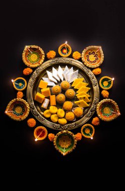 Mutlu Diwali - Tatlı ya da mithai ile Rangoli Çiçeği ve Diwali ya da Hindistan 'daki diğer festivaller için kaselerde diya, seçici bir odak noktası