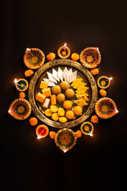 Mutlu Diwali - Tatlı ya da mithai ile Rangoli Çiçeği ve Diwali ya da Hindistan 'daki diğer festivaller için kaselerde diya, seçici bir odak noktası