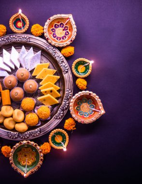 Mutlu Diwali - Tatlı ya da mithai ile Rangoli Çiçeği ve Diwali ya da Hindistan 'daki diğer festivaller için kaselerde diya, seçici bir odak noktası