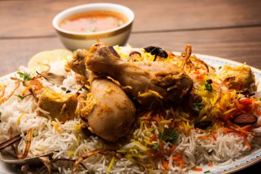 Hintli Tavuk Biryani, beyaz arka planda yoğurt ile birlikte bir terakotta kasesinde servis edildi. seçici odak